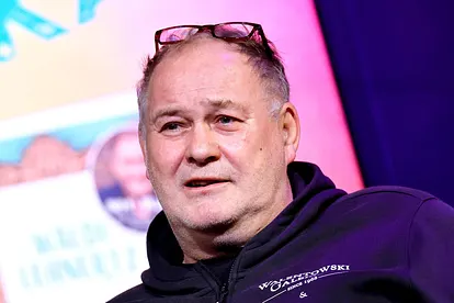 "Bares für Rares"-Waldi sitzt auf einem Sofa und schaut verschmitzt nach links oben.
