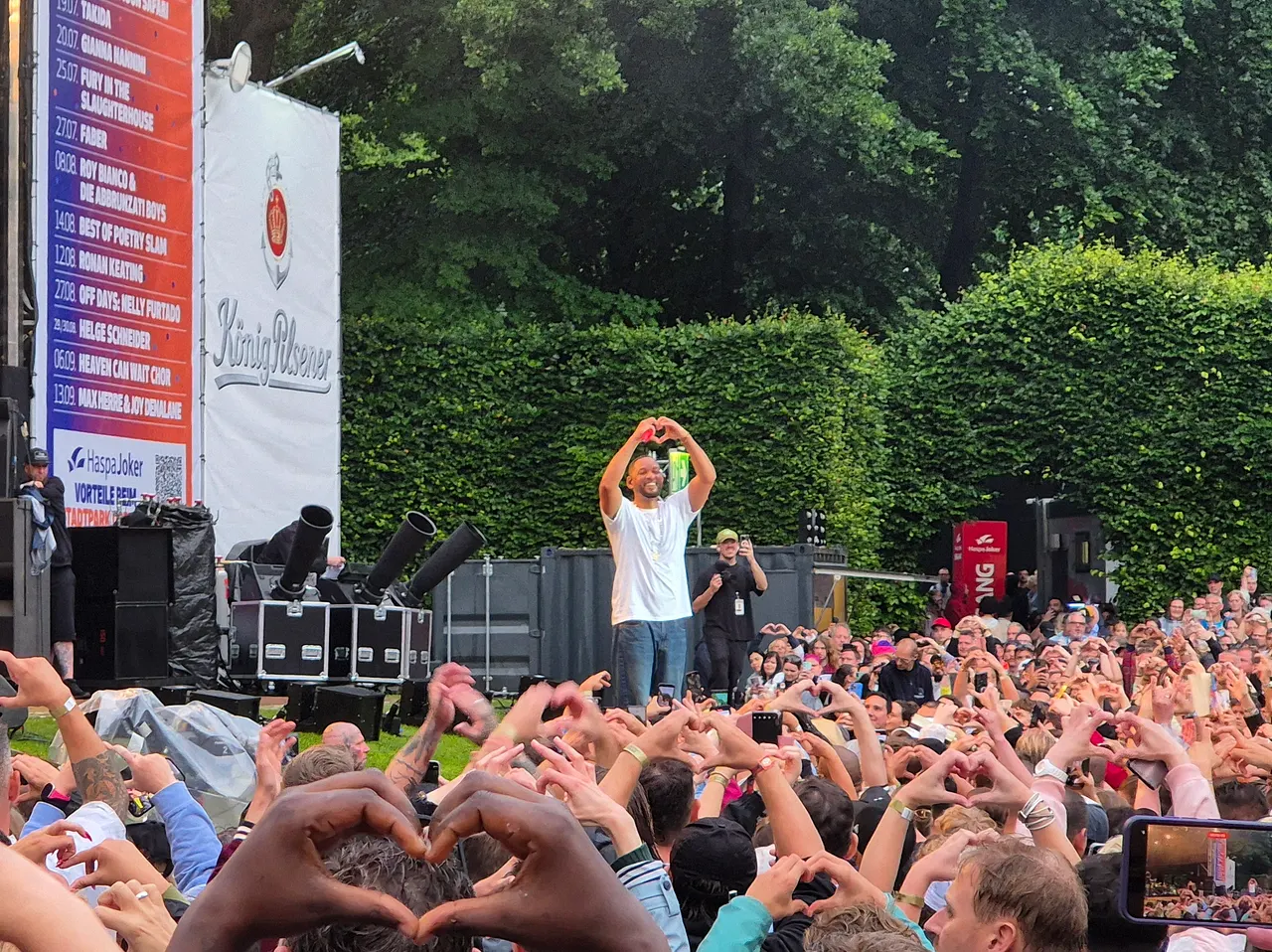 20250713_205636(0) Will Smith steht vor dem Konzertpublikum und formt mit seinen Händen ein Herz. - Foto: InTouch