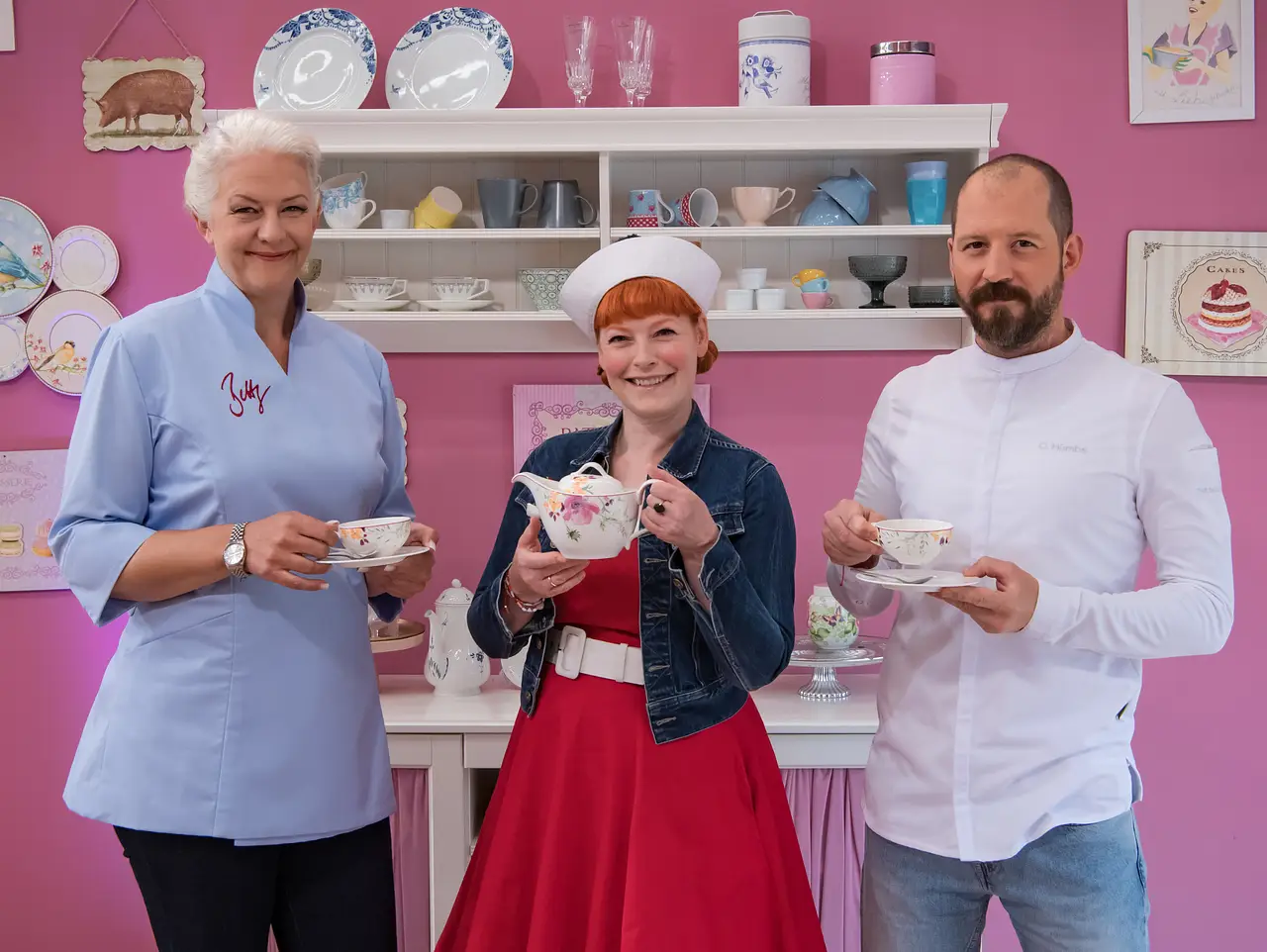 7835560_13156432 Die Jury von Das große Backen posiert mit einem Teeservice vor einer pinken Wand - Foto: SAT.1 / Claudius Pflug