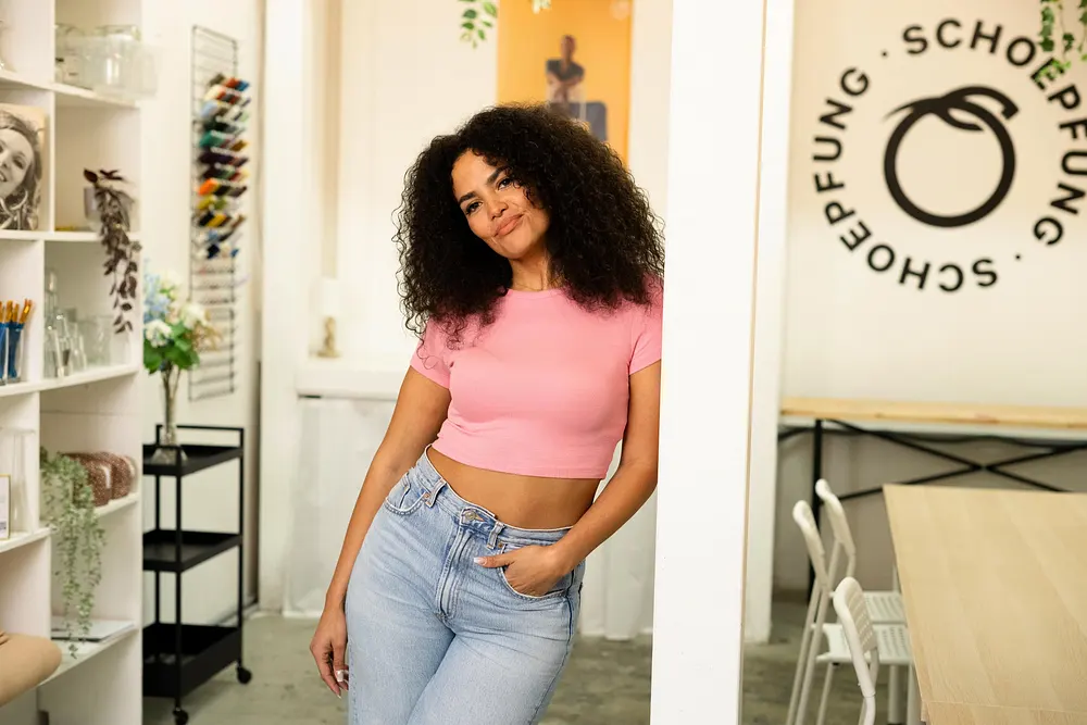 Kandidatin Viviane lehnt lässig an einer Säule in einem pinken Top und einer blauen Jeans. Kandidatin Viviane lehnt lässig an einer Säule in einem pinken Top und einer blauen Jeans.