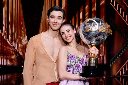 Diego Pooth und Ekaterina Leonova lächeln in die Kamera. Ekaterina hält den "Let's Dance"-Pokal.