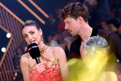 Ekaterina Leonova, hier im roten Kleid, spricht mit angestrengtem Blick in ein RTL-Mikrofon, Valentin Lusin schaut sie erschrocken an. 