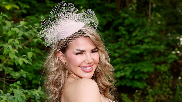 Kim Virginia mit einem strahlendem lächeln auf einem Event.