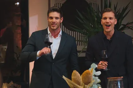 Martin Braun und Felix Stein feiern mit einem Glas Wein in der Hand die Ankunft der Kandidatinnen.