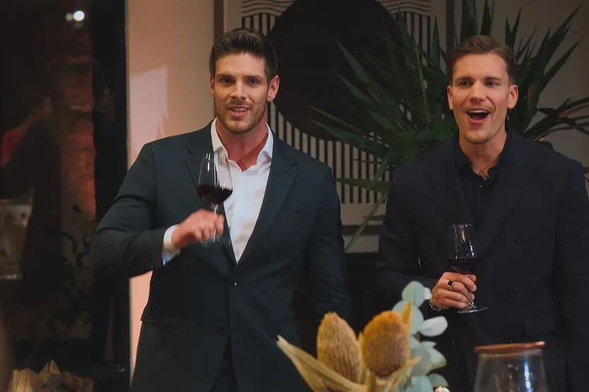 Martin Braun und Felix Stein feiern mit einem Glas Wein in der Hand die Ankunft der Kandidatinnen.