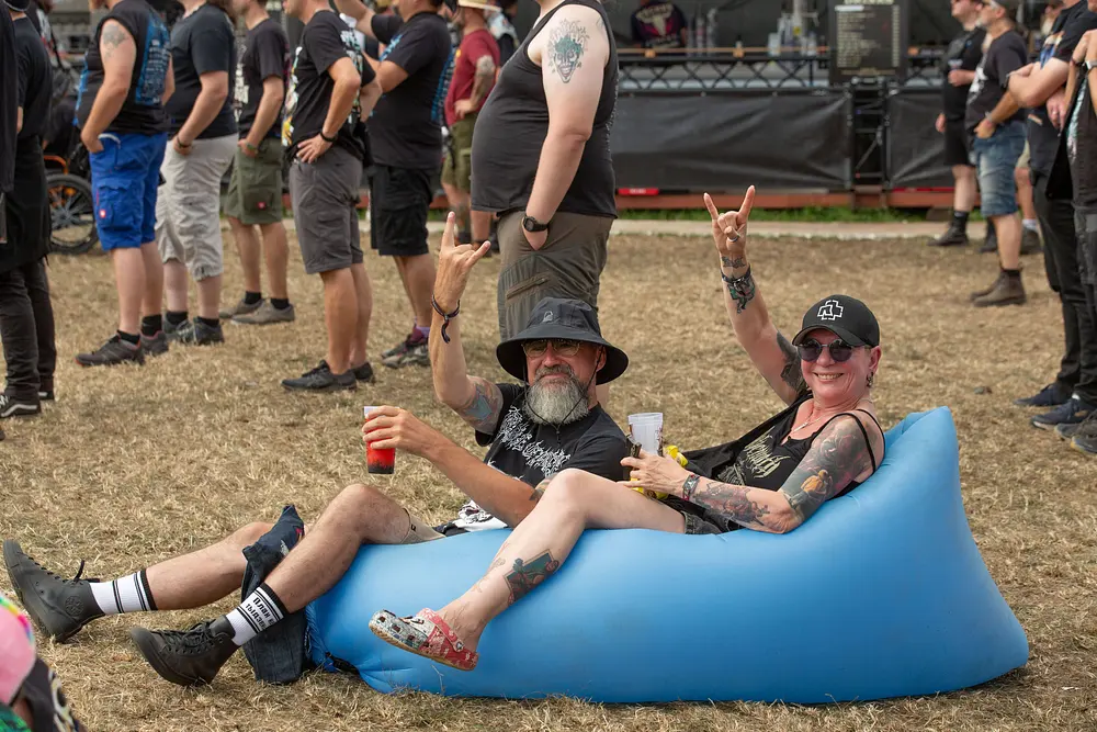 Zwei Wacken-Festivalbesucher auf einem blauen Sitzsack. Zwei Wacken-Festivalbesucher auf einem blauen Sitzsack.