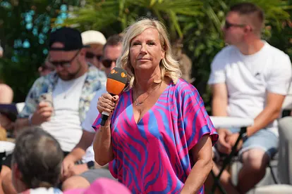 Andrea Kiewel steht auf der Bühne vom "ZDF Fernsehgarten" und blickt ernst.