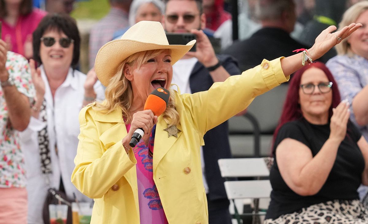 Andrea Kiewel im gelben Mantel im Fernsehgarten