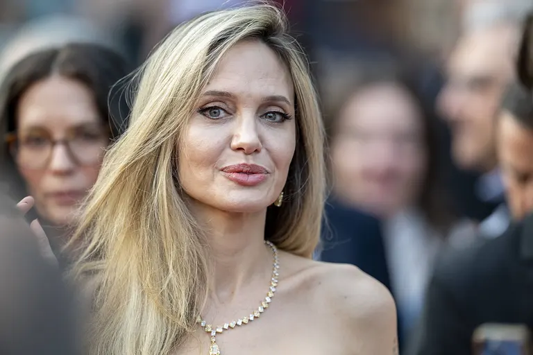 Angelina Jolie schmunzelt und blickt in die Kamera.