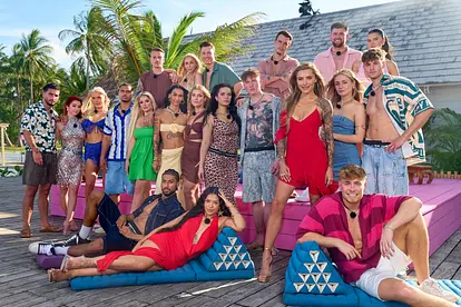 Der Cast der fünften Staffel von AYTO-VIP posiert mit Moderatorin Sophia Thomalla vor ihrer Villa am Strand