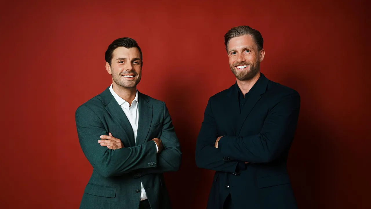 Die beiden Bachelors lächeln in die Kamera.