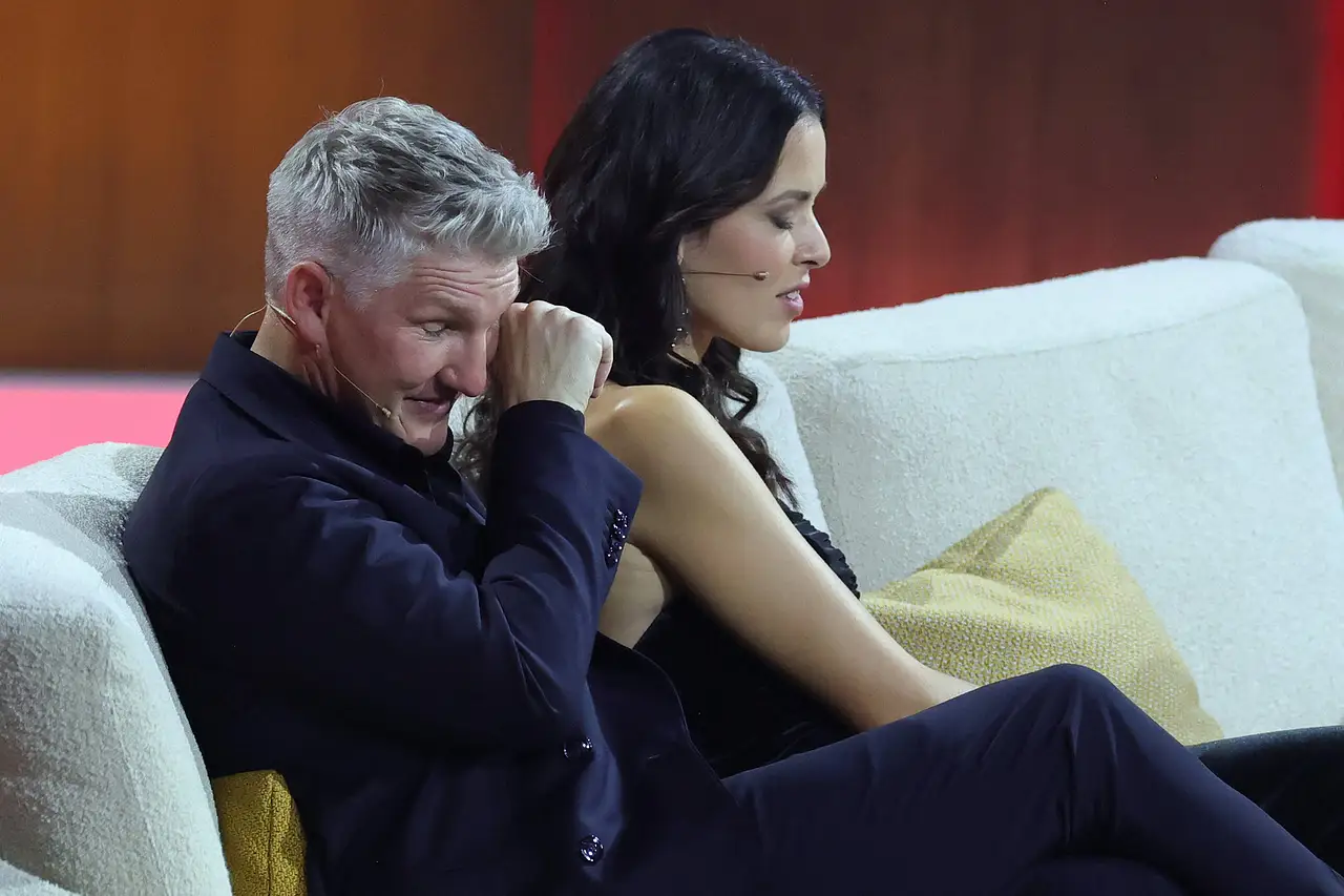 Ana Ivanovic und Bastian Schweinsteiger sitzen nebeneinander auf einer Couch. Sie blickt zu Boden, er reibt sich die Augen.