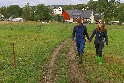 "Das Bauer sucht Frau"-Paar Anna und Paul läuft Hand in Hand über einen Wiesenweg. Sie wagen jetzt den nächsten Schritt.