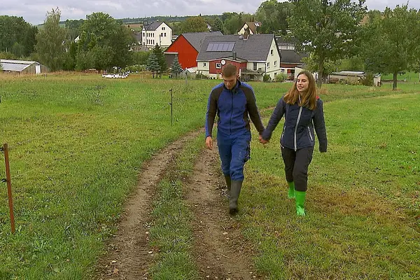"Das Bauer sucht Frau"-Paar Anna und Paul läuft Hand in Hand über einen Wiesenweg. Sie wagen jetzt den nächsten Schritt.