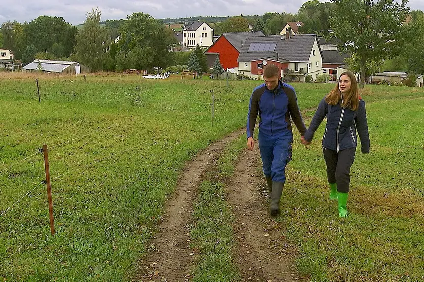 "Das Bauer sucht Frau"-Paar Anna und Paul läuft Hand in Hand über einen Wiesenweg. Sie wagen jetzt den nächsten Schritt.