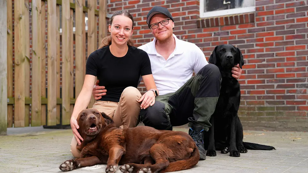 Die "Bauer sucht Frau"-Kandidaten von 2024, Andre und Sophie, posieren mit zwei Hunden.