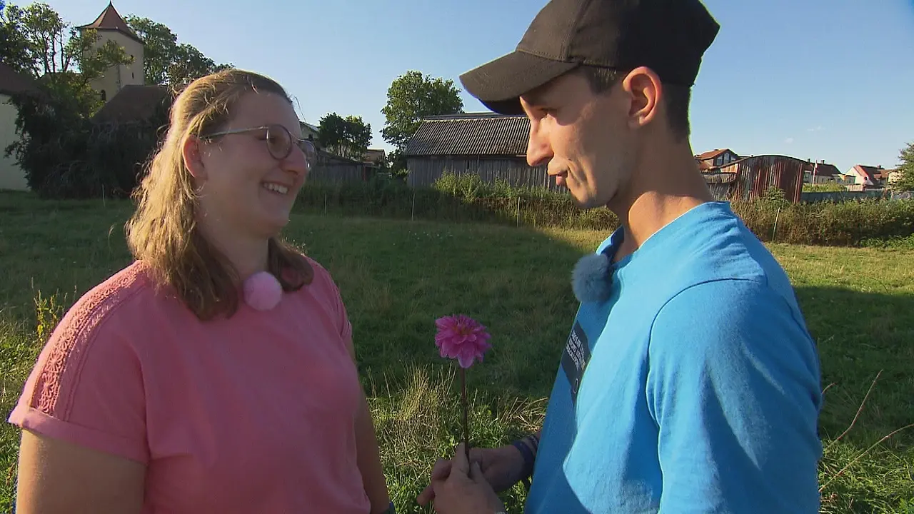"Bauer sucht Frau": Michael steht Julia gegenüber und hält eine Blume in den Händen
