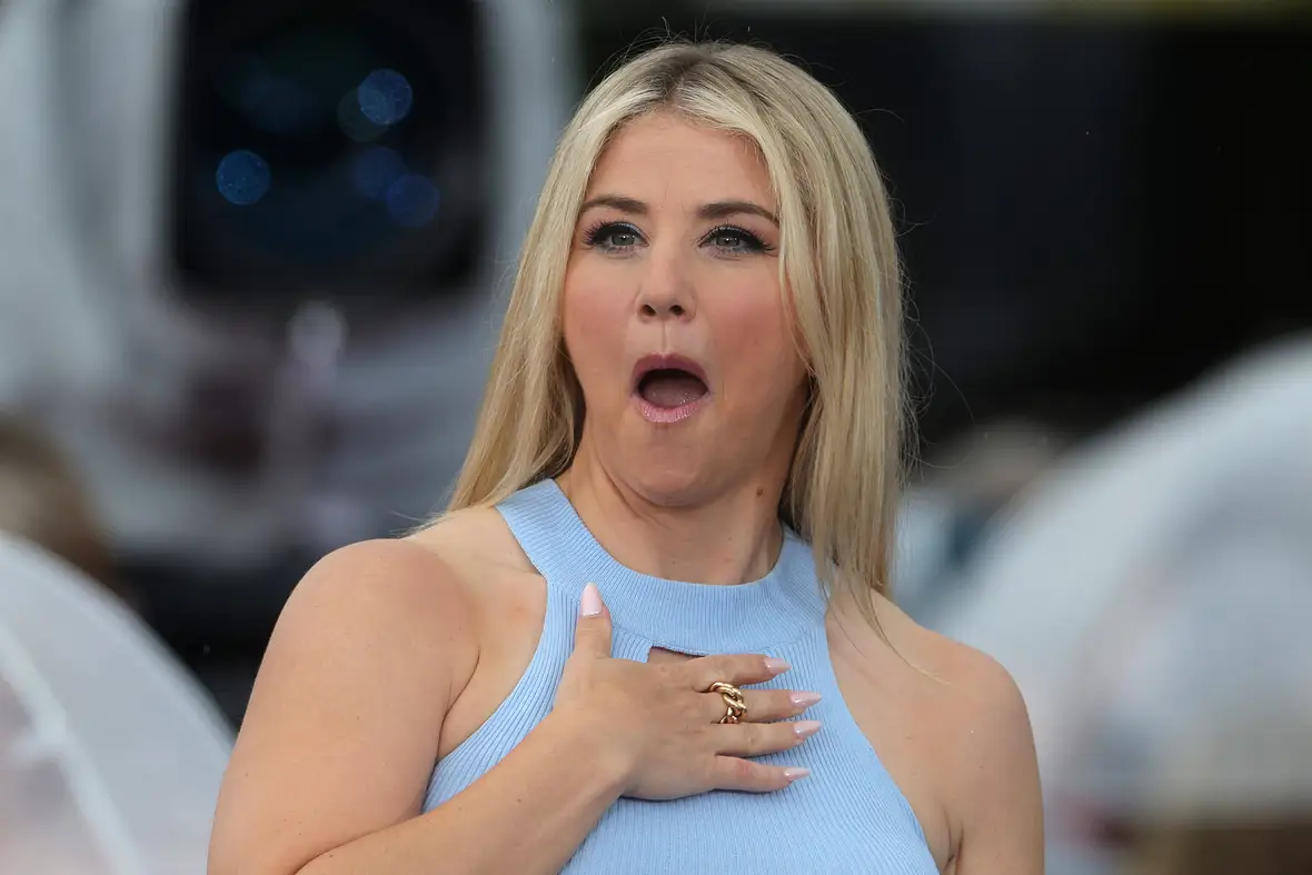 Beatrice Egli hält überrascht die Hand auf ihre Brust und reißt den Mund auf. 
