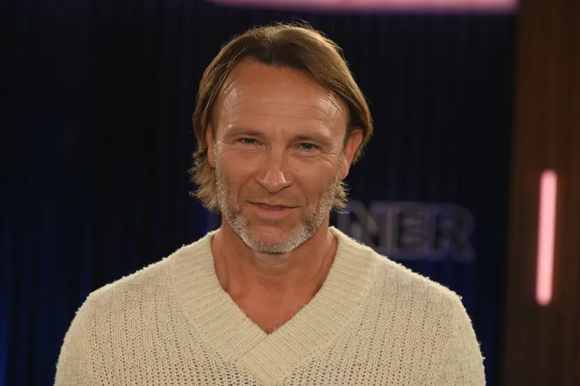 Bernhard Bettermann mit beigen Pullover lächelt in die Kamera.