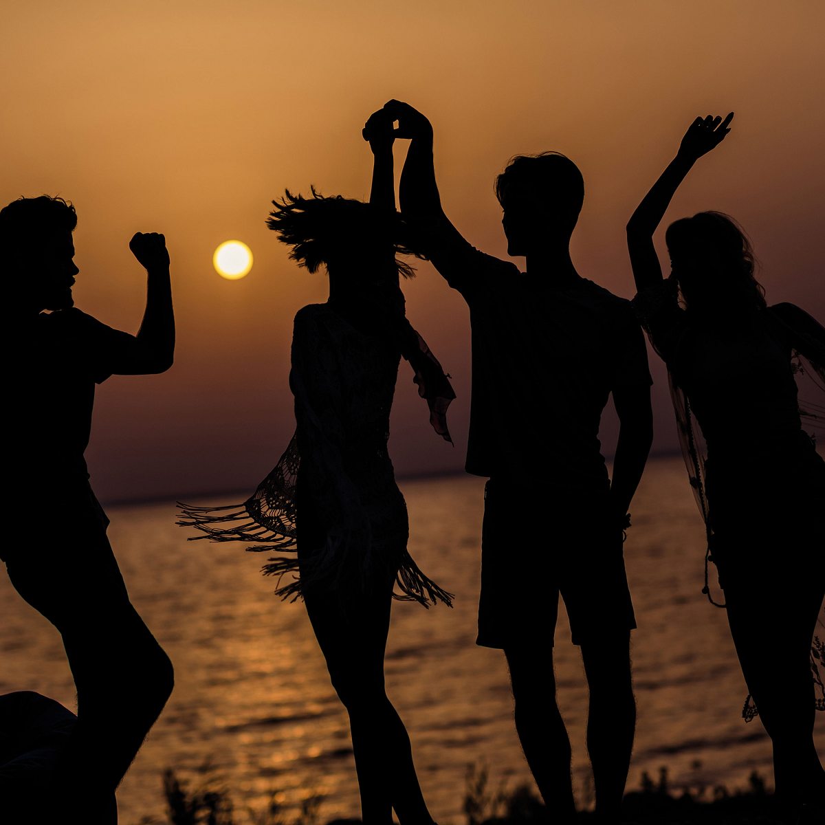 Menschen tanzen am Strand