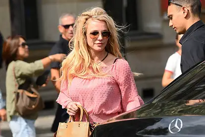 Britney Spears wird mit Sonnenbrille und Löwenmähne auf einer Straße abgelichtet. Sie sieht ernst aus.