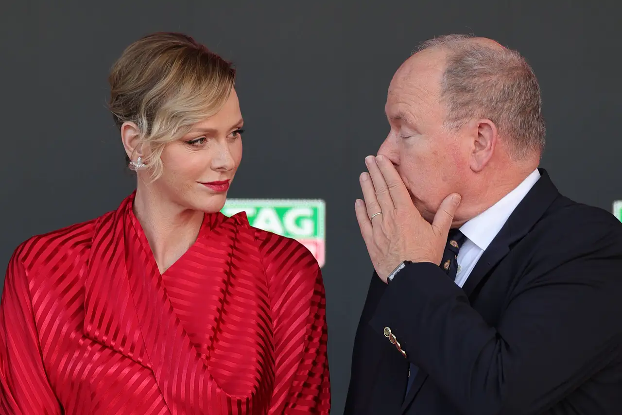 charlene-von-monaco-rivalinnen-imago1062442098 Charlène von Monaco trägt beim Grand Prix ein rotes Kleid. Fürst Albert scheint ihr etwas zuzuflüstern. - Foto: IMAGO / Action Plus