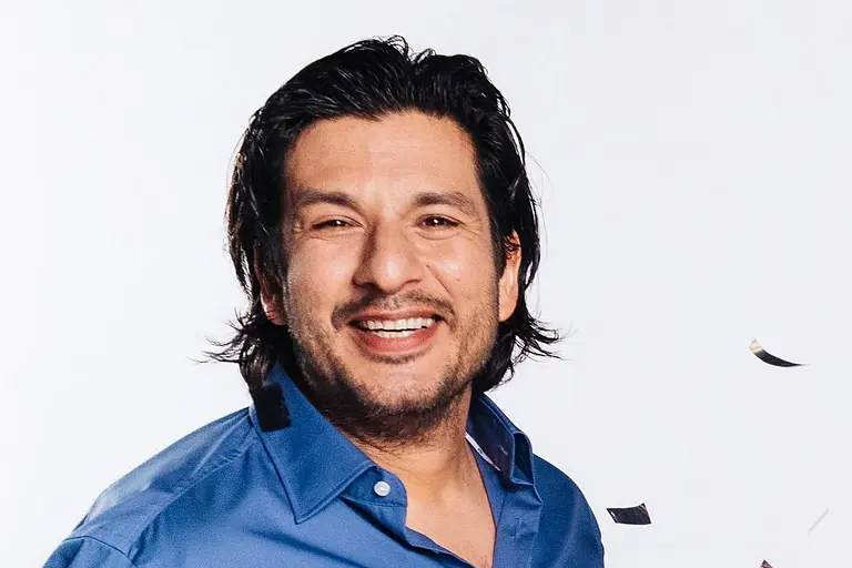 Francisco Medina mit blauem Hemd lacht in die Kamera.