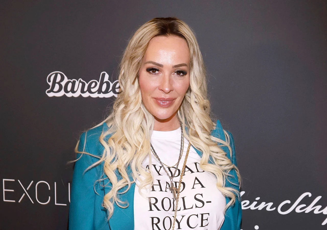 Cora Schumacher trägt offene, gelockte Haare, ein weißes T-Shirt und einen türkisen Blazer. Sie lächelt sanft. - Foto: IMAGO / Future Image