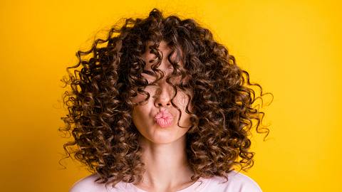 Mit einem Curler kannst du dir ganz einfach Locken zaubern. - Foto: iStock/ Deagreez