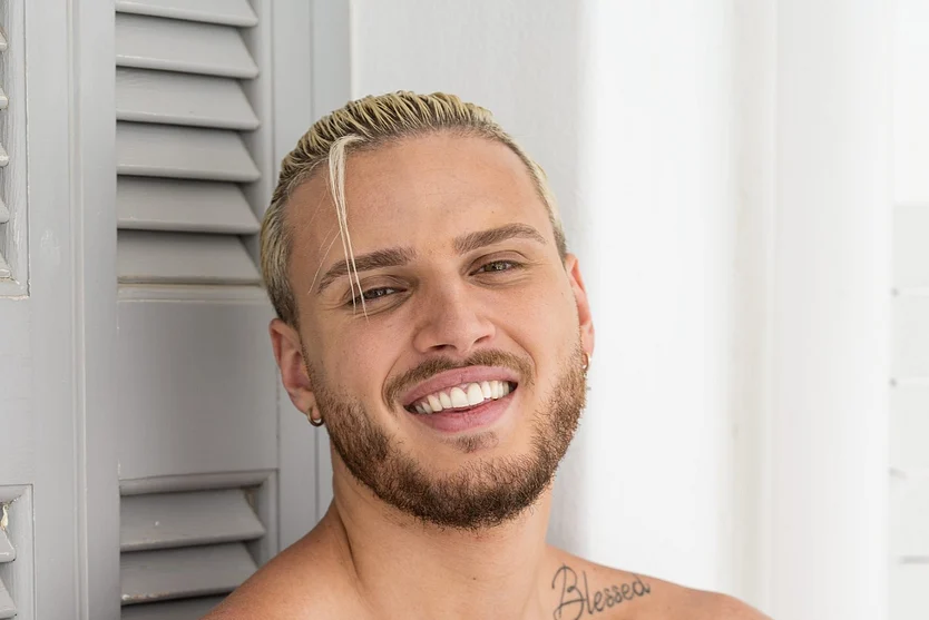 Danilo Sellaro posiert lächelnd und oberkörperfrei für die Kamera