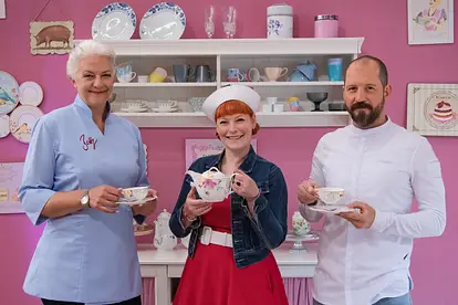 Die Jury von "Das große Backen" posiert mit einem Teeservice vor einer pinken Wand