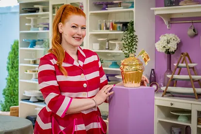 Enie van de Meiklokjes posiert mit dem goldenen Cupcake im Zelt von "Das große Backen"