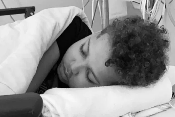 Delivio Misiedjan (12) liegt im Krankenhausbett während seiner Krebsbehandlung