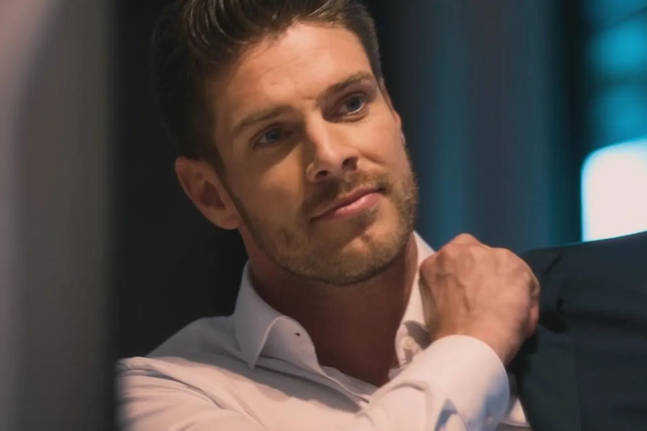 Bachelor Martin Braun schaut in einen Spiegel und zieht sich sein Jacket an