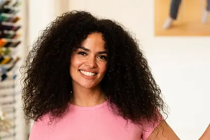 Vivi von "Die Bachelors" posiert mit ihrer linken Hand an der Wand lehnend lächelnd in die Kamera