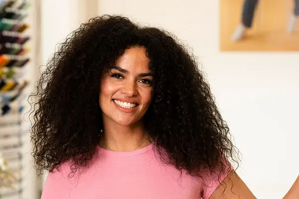 Vivi von "Die Bachelors" posiert mit ihrer linken Hand an der Wand lehnend lächelnd in die Kamera
