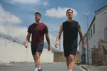 Martin Braun und Felix Stein, die Bachelors, laufen in Sportoutfits eine verlassene Straße entlang.