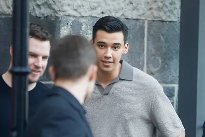 Diego Pooth in grauen Oberteil schaut erschrocken zu einem unbekannten Mann hinüber.