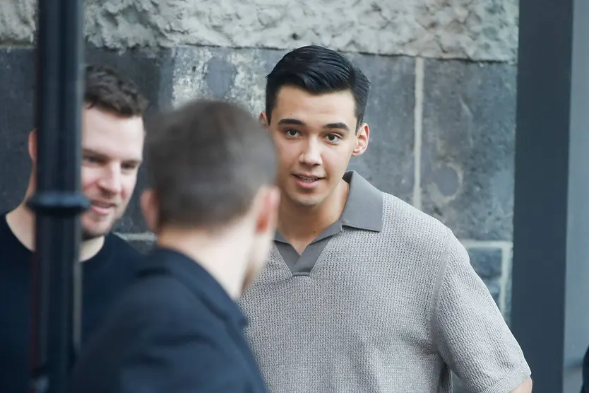 Diego Pooth in grauen Oberteil schaut erschrocken zu einem unbekannten Mann hinüber. 