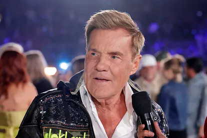 Dieter Bohlen sieht zur Seite, ihm wird ein Mikrofon vors Gesicht gehalten.