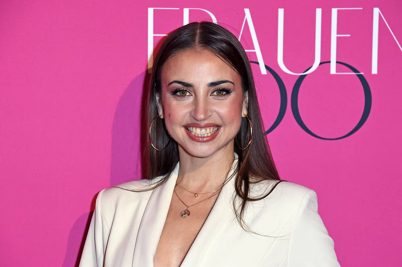 Ekaterina Leonova trägt einen weißen Blazer und stahlt vor einem pinken Hintergrund in die Kamera. Sie schwebt auf Wolke 7! - Foto: IMAGO / Gartner