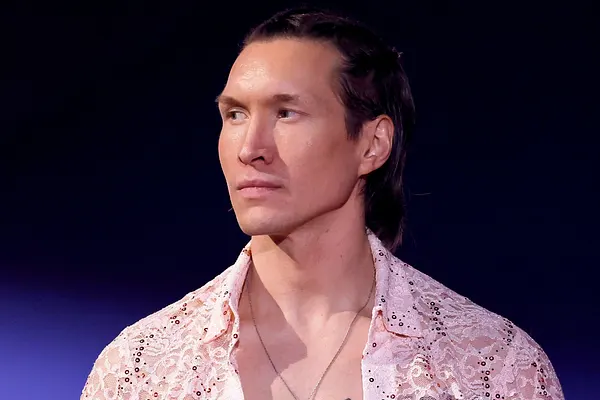 Evgeny Vinokurov mit offenem weißem Hemd schaut ernst in die Ferne.