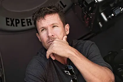 Felix Baumgartner kniet mit ernstem Gesicht und einer Hand am Kinn in seiner Kapsel.