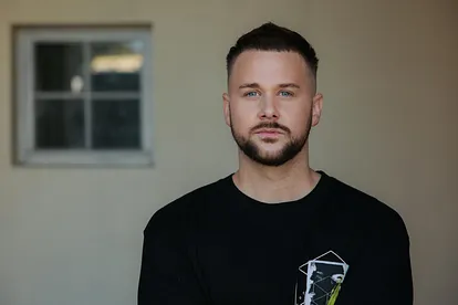 Felix van Deventer schaut im schwarzen Shirt ernst in die Kamera.