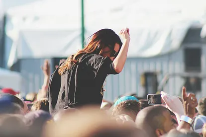 Frau auf einem Festival mit einem Arm in der Luft