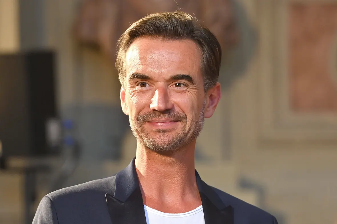 Florian Silbereisen blickt in Richtung Kamera und lächelt dabei ein wenig.