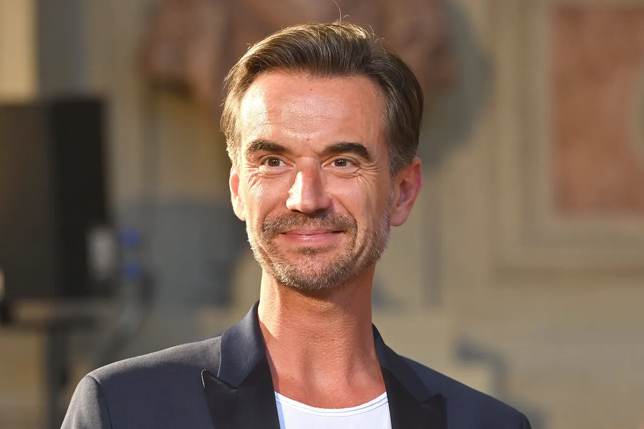 Florian Silbereisen blickt in Richtung Kamera und lächelt dabei ein wenig.