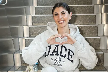 Yeliz Koc kann wieder lächeln, denn ein neuer "Forsthaus Rampensau"-Partner soll gefunden worden sein. Das Bild zeigt sie im Hoodie, wie sie ein Herz mit ihren Händen formt.