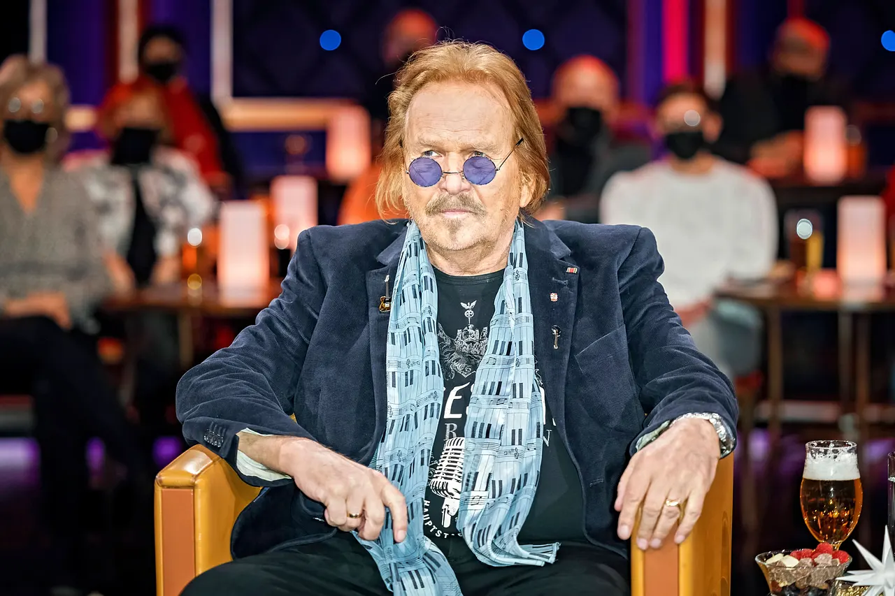Frank Zander sitzt auf einem Sessel und schaut in die Ferne 