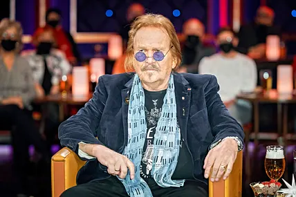 Frank Zander sitzt auf einem Sessel und schaut in die Ferne 